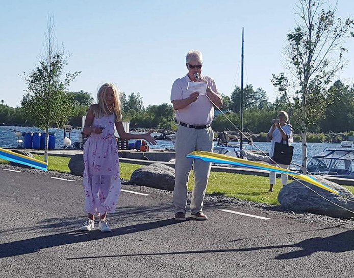 Nu är det klippt! Elvaåriga Klara Rylander klippte bandet vid invigningen av Rövögersvägen. Vägsamfällighetens ordförande Olof Degerfeldt invigningstalade.